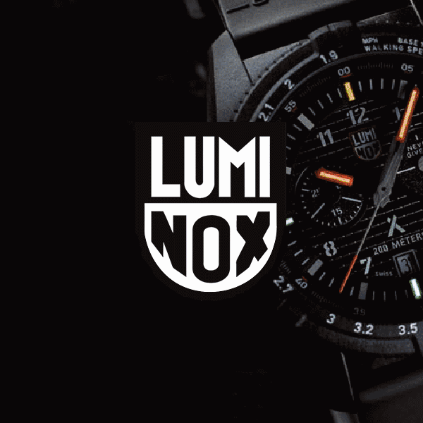Nærbilde av en Luminox-klokke som viser tiden, med lysende oransje visere og markører. Luminox-logoen er fremtredende.