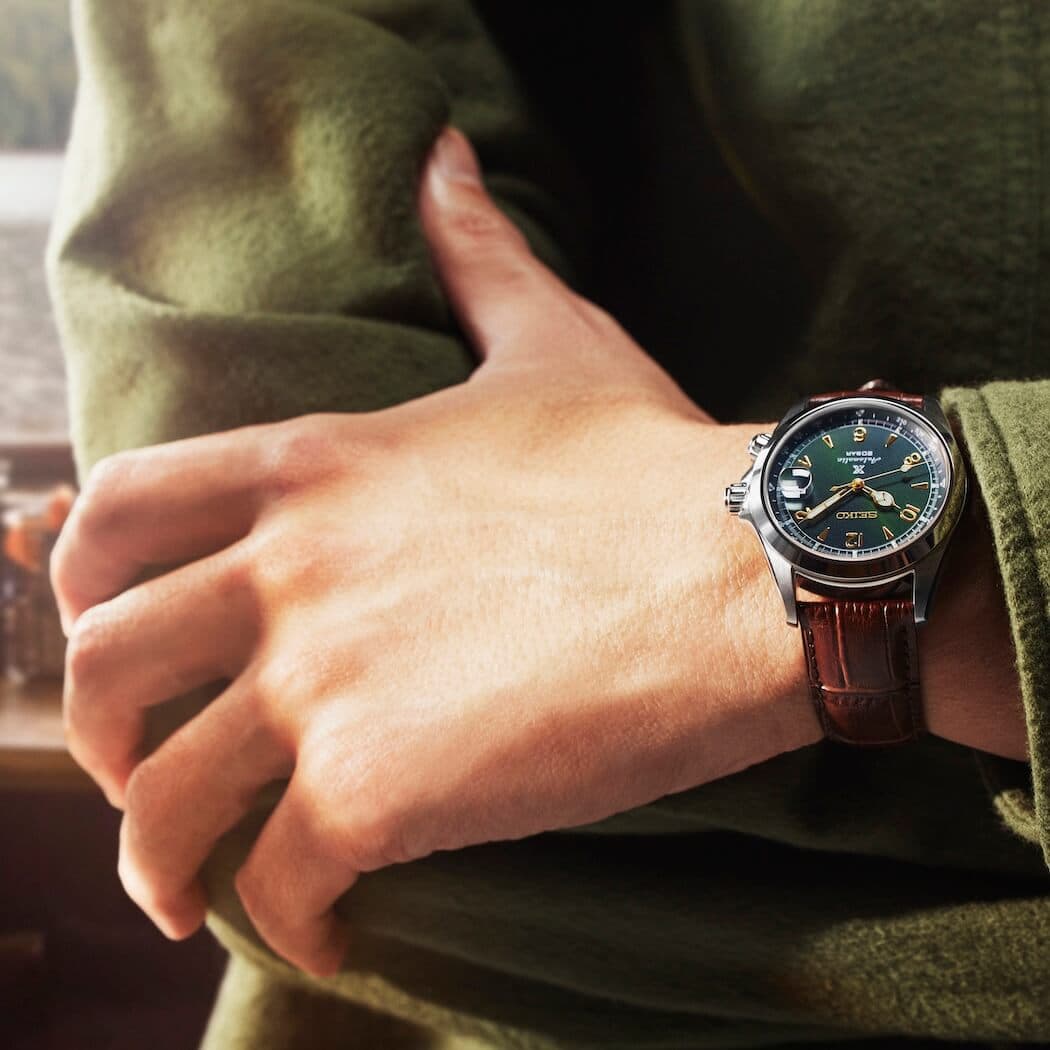 Person med grønn jakke og et stilig armbåndsur med grønn urskive og brun skinnreim, med armene i kors.